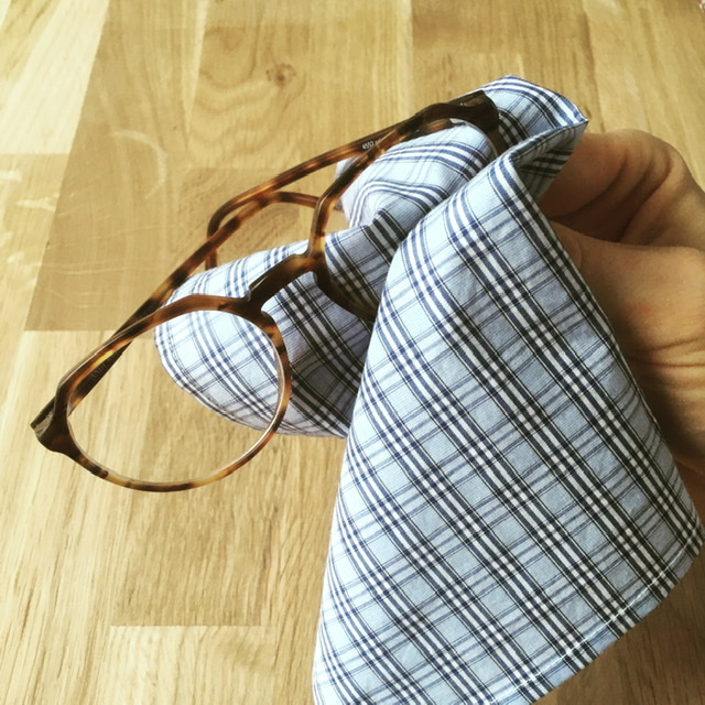 Brille die mit Brillenputztuch aus Baumwolle geputzt wird
